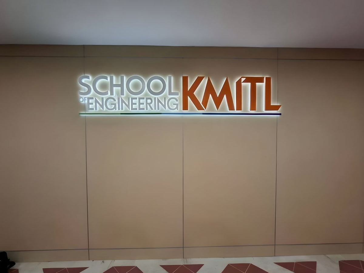 ป้ายไฟออกหลัง (backlit sign) ติดผนังแสดงข้อความ "SCHOOL of ENGINEERING KMITL" — ตัวอักษรโลหะมีไฟ สถาบันเทคโนโลยีพระจอมเกล้าเจ้าคุณทหารลาดกระบัง