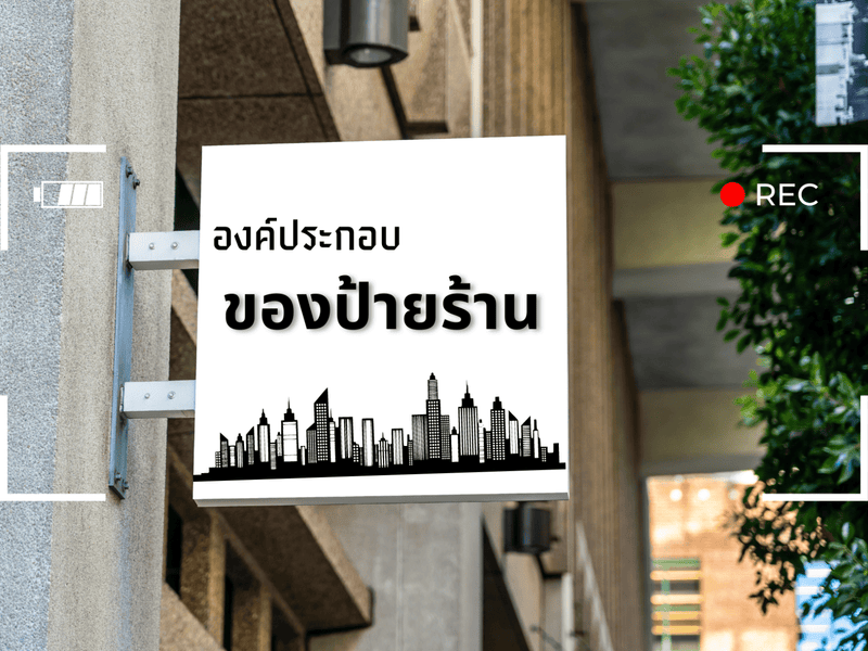 ป้ายสี่เหลี่ยมขาว พื้นหลังเมืองดำ ตัวอักษรไทยดำ ในองค์ประกอบป้ายร้านดี