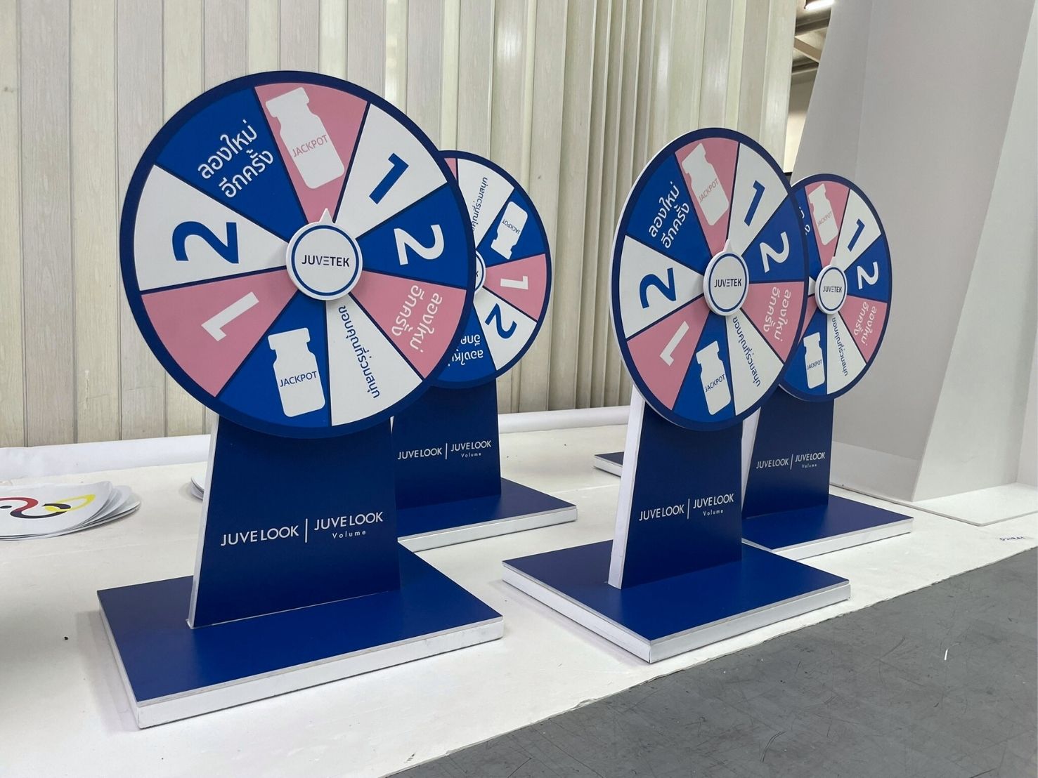 ป้ายหมุนวงล้อขนาดเล็ก สีน้ำเงินชมพู พื้นที่สีขาว บนแท่นสีน้ำเงิน