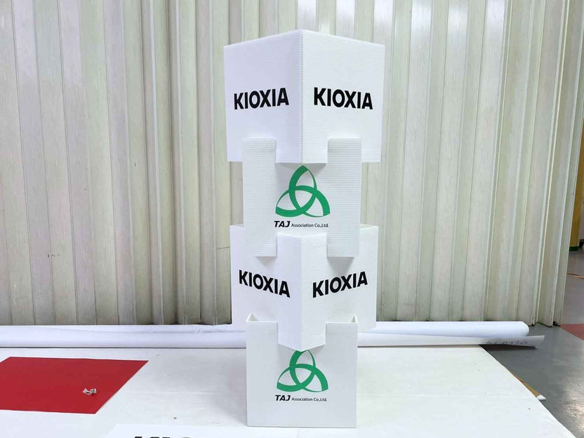 กล่องลูกเต๋า Kioxia สีขาวทรงสแต็ค พิมพ์โลโก้เขียวและ Taj Association
