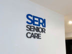 ป้ายไดคัทอะคริลิคตัวนูน Seri Senior Care สีน้ำเงินเทา 3D บนผนังขาว