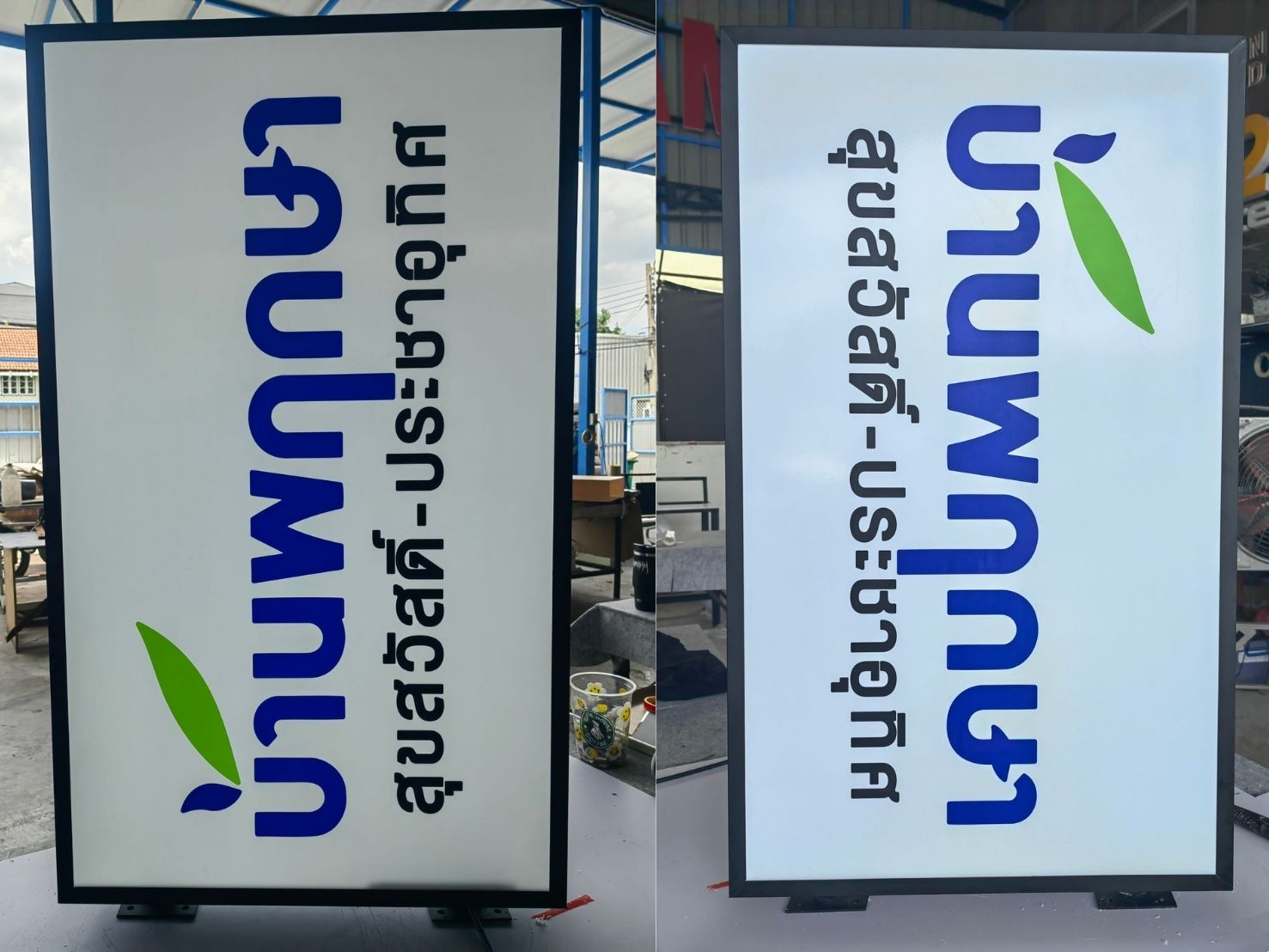 ป้ายไฟอะคริลิค LED ขาวตัวอักษรไทยน้ำเงินใบไม้เขียวกรอบดำติดยื่นผนัง