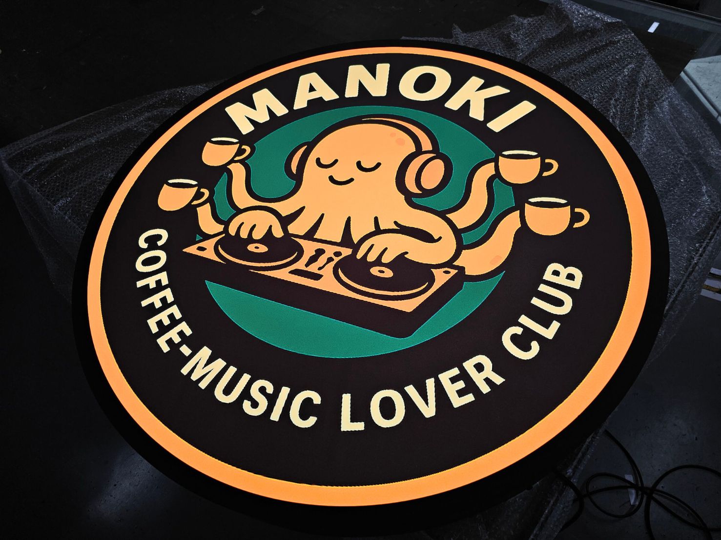 ป้ายไฟวงกลม Manoki Coffee-Music Lover Club ปลาหมึก DJ ถือกาแฟ