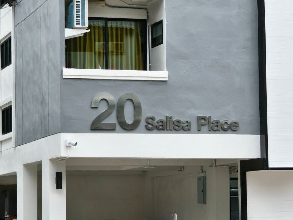ป้ายคอนโดมิเนียมเงินเมทัลลิกแสดง 20 Salsa Place บนผนังเทา