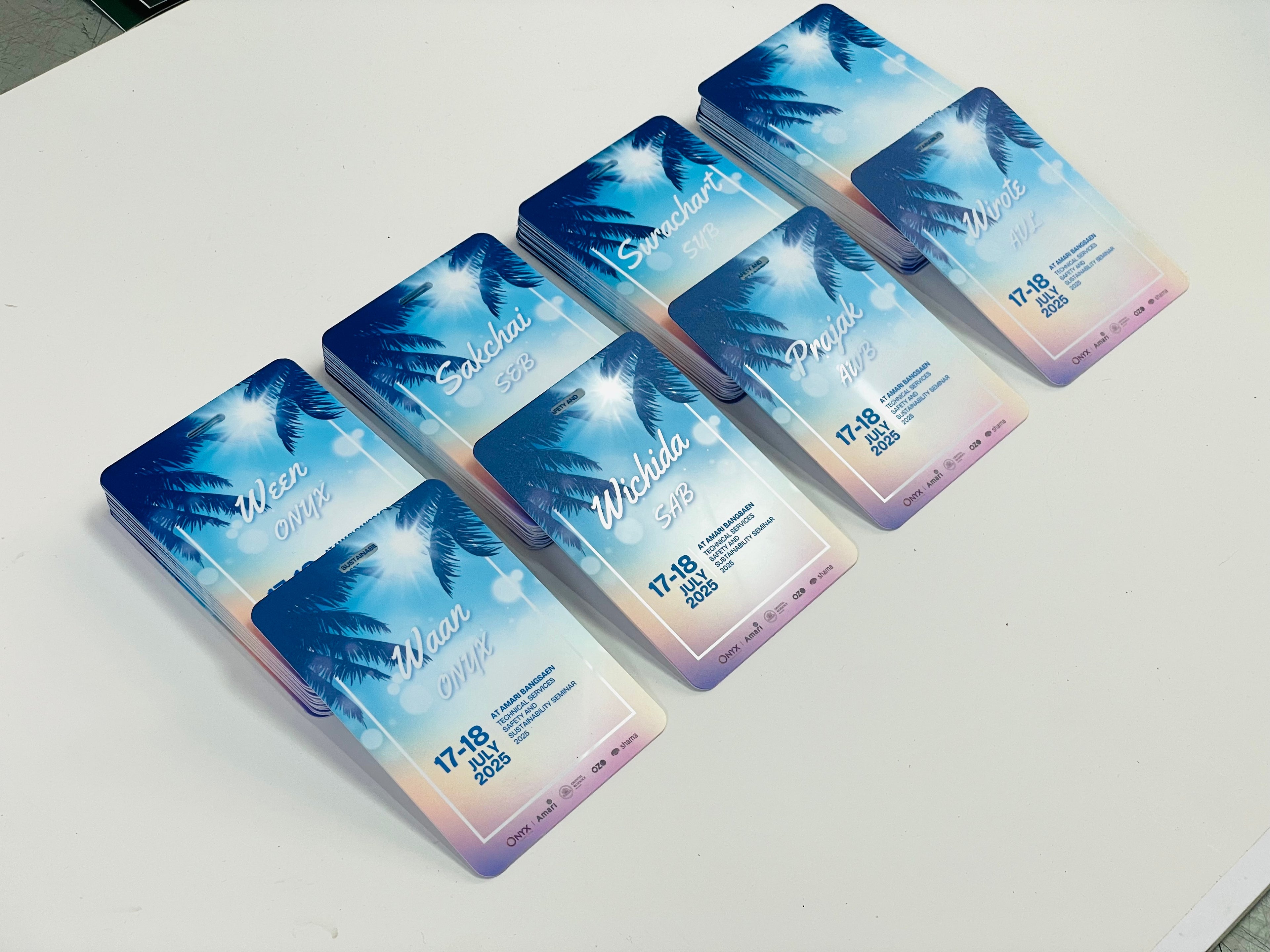 ป้ายห้อยคออีเวนต์ไล่สีน้ำเงินชมพู พื้นหลังท้องฟ้าทำลาย ต้นปาล์มซิลูเอต