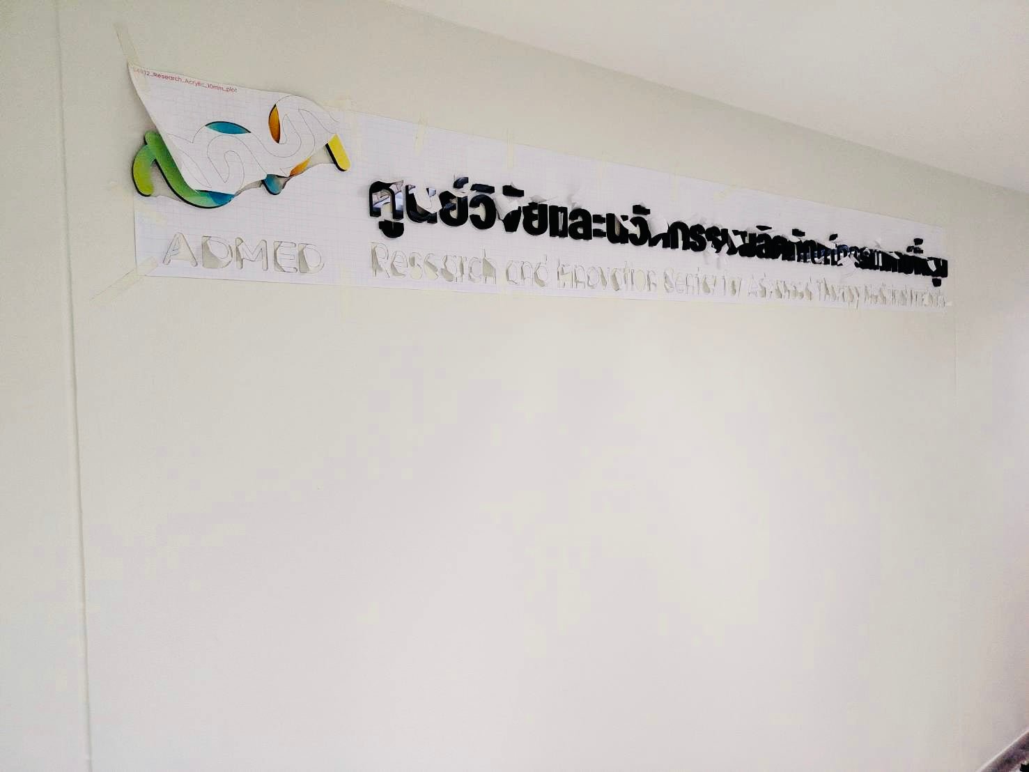ป้ายอะคริลิคชื่อบริษัท admec ติดผนัง โลโก้มาสก์สีเขียวเหลือง