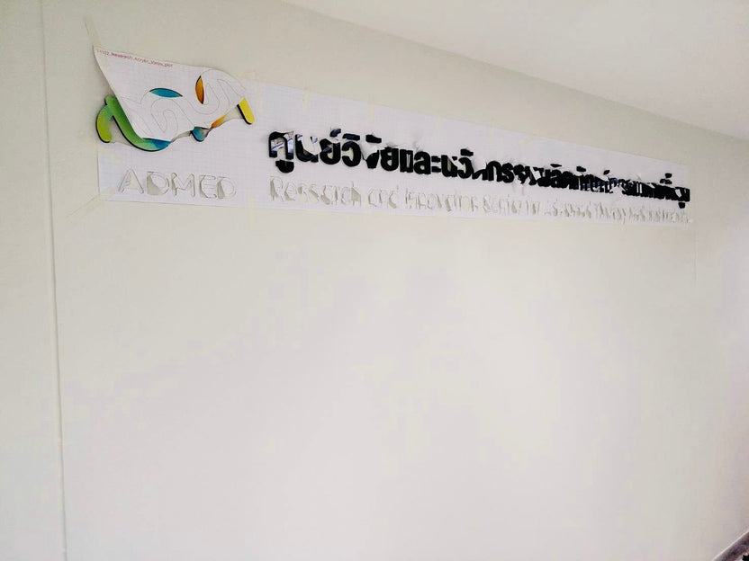 ป้ายอะคริลิคชื่อบริษัท admec ติดผนัง โลโก้มาสก์สีเขียวเหลือง