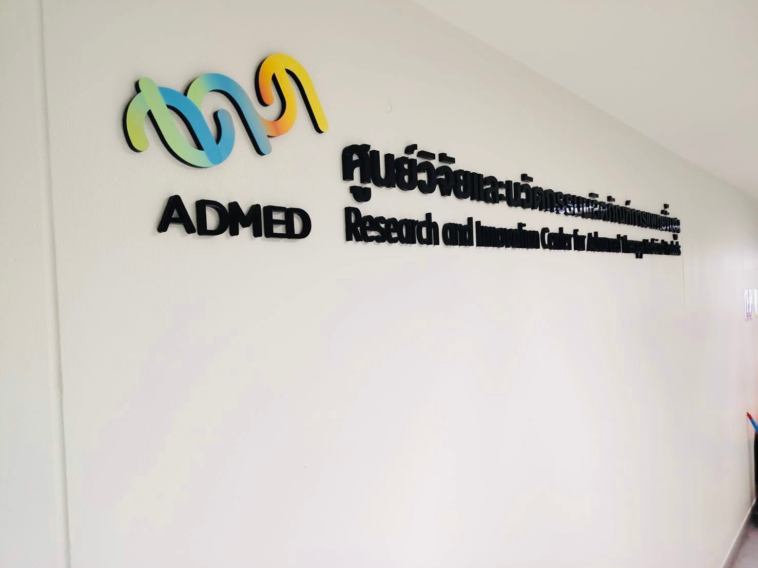 ป้ายอะคริลิคชื่อบริษัท admed สีดำ 3D ติดผนังขาวลายวนสีสัน
