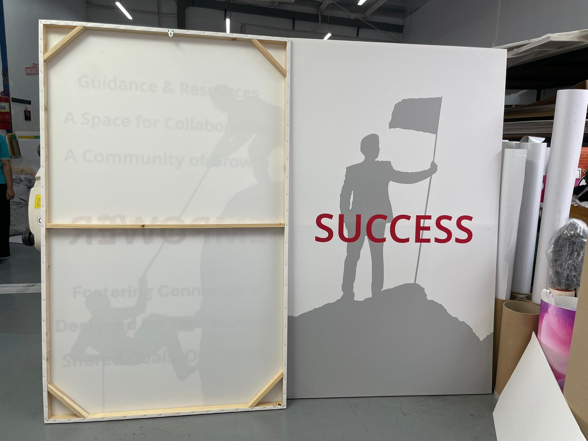 ภาพแคนวาสขาว เงาคนสีเทาถือธงบนยอดเขา คำว่า success สีแดงตัวหนา
