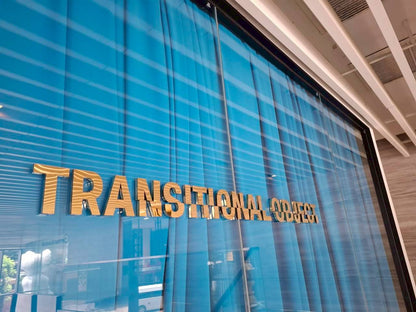 ป้ายสแตนเลสสีทองเงา 3D คำว่า transitional object บนกระจกสีน้ำเงิน