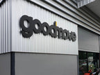ป้ายโลโก้ Goodmove 3D สีดำ พื้นผนังเมทัลชีทขาว