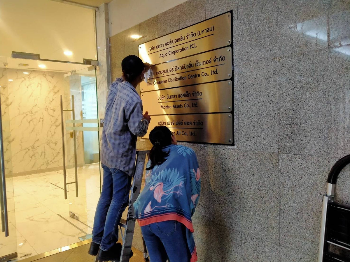 ป้ายชื่อบริษัท หลังอะคริลิคดำทับหน้าสแตนเลสฉลุเลเซอร์ - Octopus Media Solutions